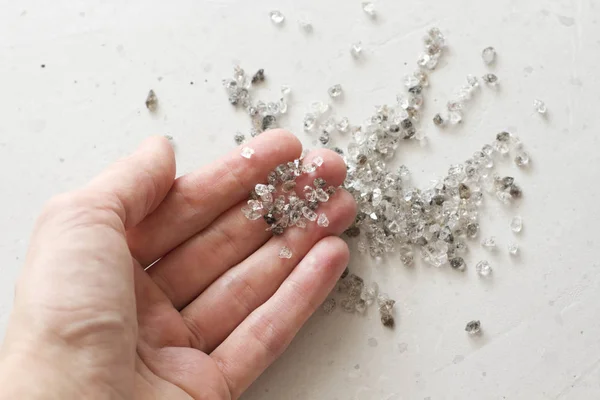 Diamantes naturales crudos, cuarzo de grafito están en la mano. Una dispersión — Foto de Stock