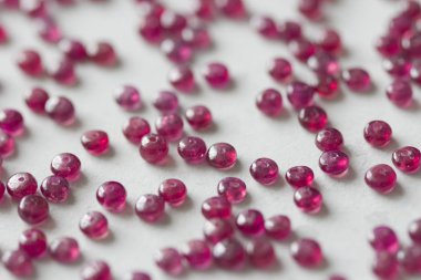 Yakut taşları beyaz bir masanın üzerinde, beyaz bir arka plan da yatıyor. Doğal st