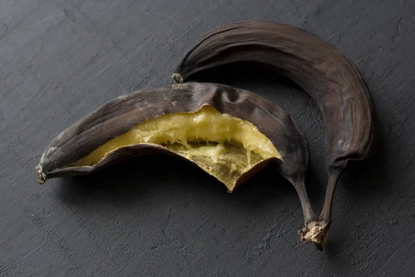 Frutas podres podres, bananas. Bananas pretas em um preto — Fotografia de Stock