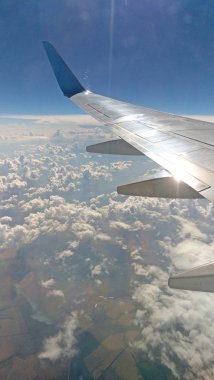 Bulutlu gökyüzü artalan pencereden dışarı uçak kanat görünümü