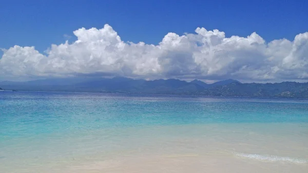 Masmavi deniz, beyaz bulutlar ve beyaz kum. Endonezya, Gili Isla — Stok fotoğraf