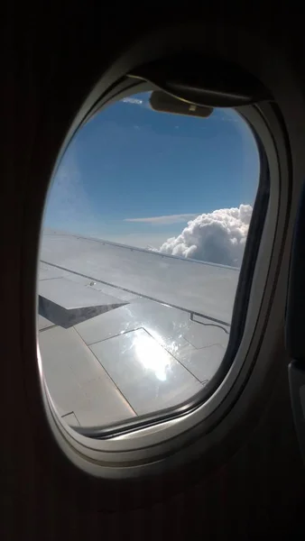 Uitzicht vanuit een vliegtuig op een blauwe hemel en witte wolken. Vliegen op — Stockfoto