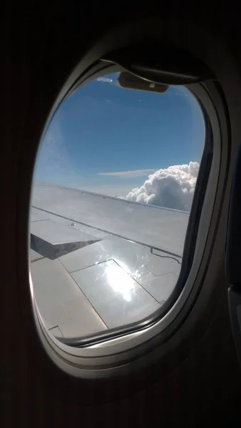 View from an airplane on a blue sky and white clouds. Flying on — Stock Photo, Image