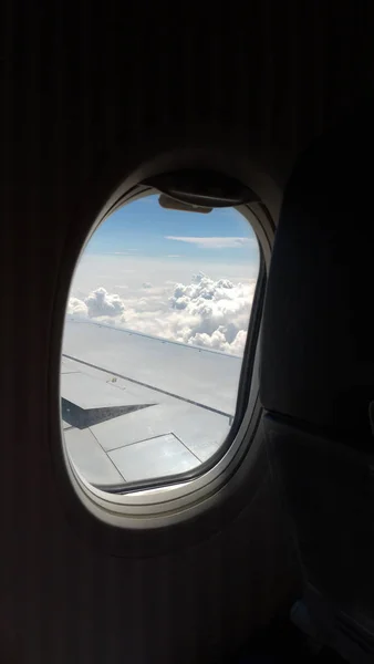 Uitzicht vanuit een vliegtuig op een blauwe hemel en witte wolken. Vliegen op — Stockfoto