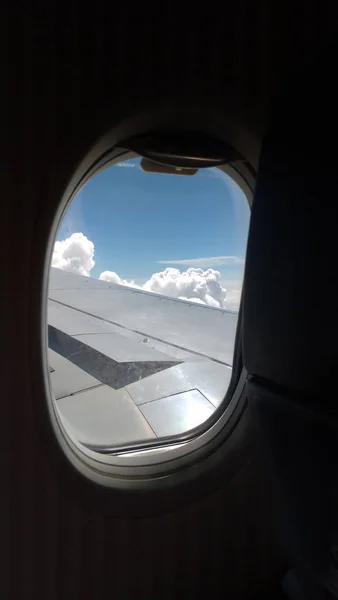 Blick aus dem Flugzeug auf blauen Himmel und weiße Wolken. Weiterfliegen — Stockfoto