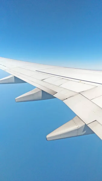 Bulutlu gökyüzü artalan pencereden dışarı uçak kanat görünümü — Stok fotoğraf