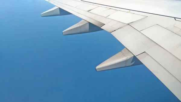 Airplane wing view out of the window on the cloudy sky backgroun — Stock Photo, Image