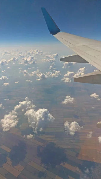 Airplane wing view out of the window on the cloudy sky backgroun — Stock Photo, Image