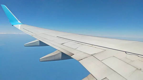 Avião vista asa fora da janela no céu nublado backgroun — Fotografia de Stock