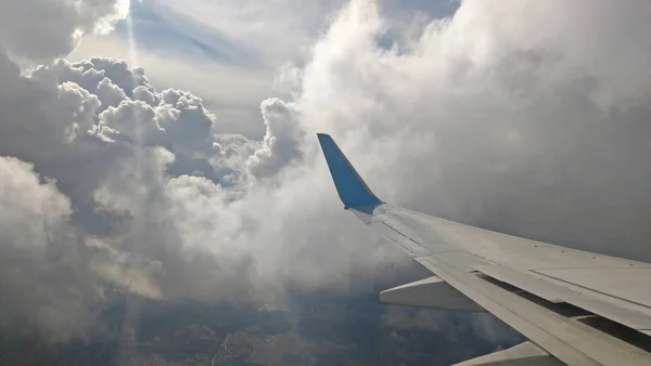 Bulutlu gökyüzü artalan pencereden dışarı uçak kanat görünümü — Stok fotoğraf