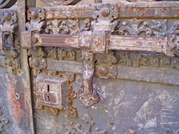 La puerta de hierro y el cerrojo con patrones. Una puerta antigua —  Fotos de Stock