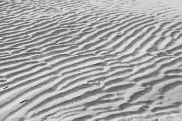 Grauer Hintergrund. Hintergrund aus Sand. schöne Wellen und Sand du — Stockfoto