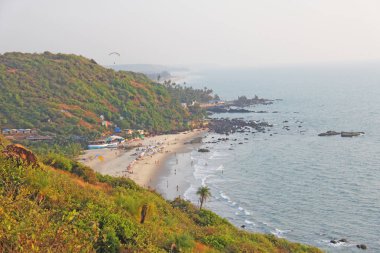 Sahildeki insanlar. Plajın tepesinden görünümü Vagator, Ind