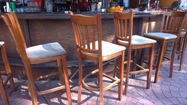 Yüksek ahşap bar tabureleri ve sokakta bir bar sayacı