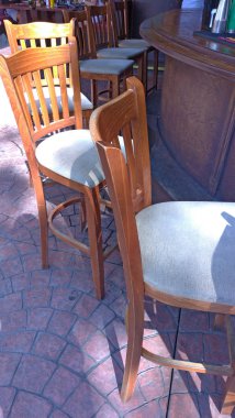 Yüksek ahşap bar tabureleri ve sokakta bir bar sayacı