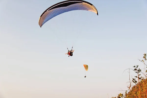 Paragliders against the blue sky. Bright paragliders fly in the — Stock Photo, Image