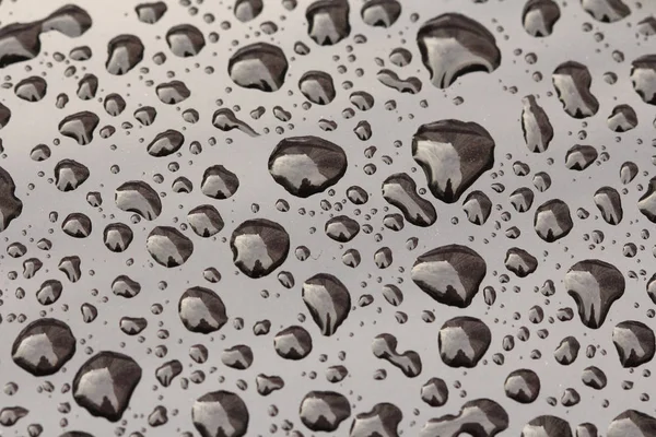 Gocce di pioggia o goccia d'acqua sul cofano dell'auto. Gocce di pioggia o — Foto Stock