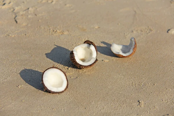 Une noix de coco brune ouverte à la viande blanche se trouve sur la plage, sur la — Photo