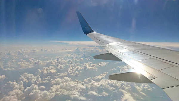 Airplane wing view out of the window on the cloudy sky backgroun — Stock Photo, Image