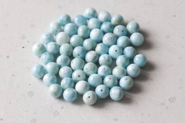 Larimar taşı. Doğal taş larimar üzerinde beyaz bir masa üzerinde yatıyor 