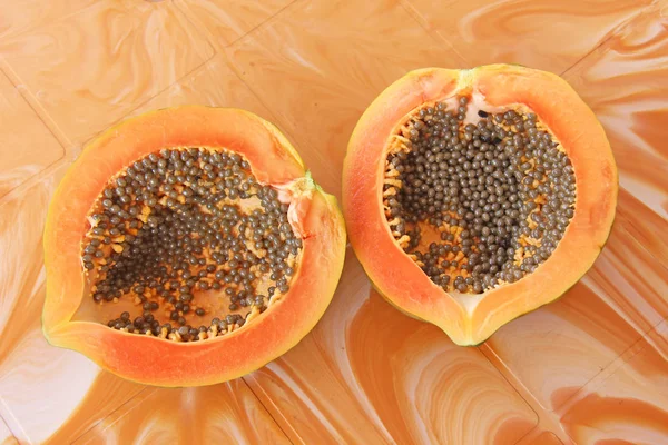 Orange open papaya with black seeds. Papaya close-up. Fruits of