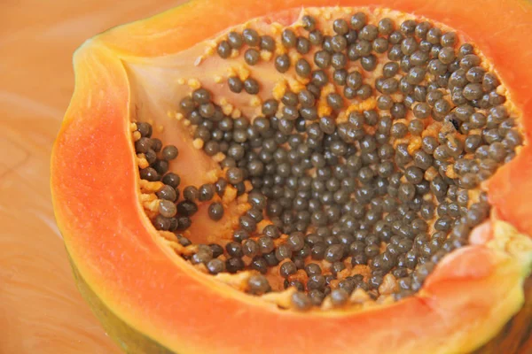 Orange open papaya with black seeds. Papaya close-up. Fruits of