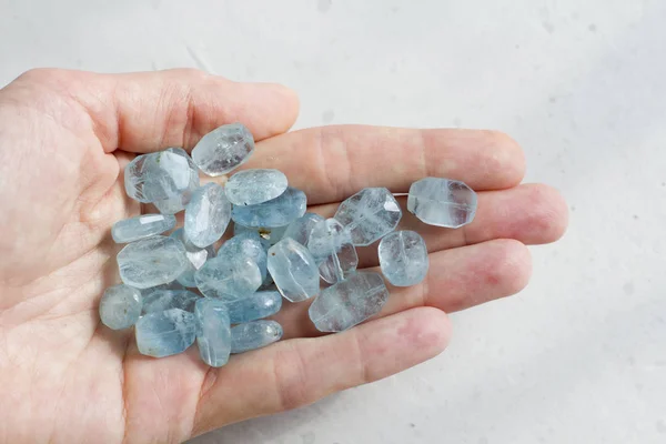 Aquamarine stone lies in the hand. Natural stone Aquamarine on a