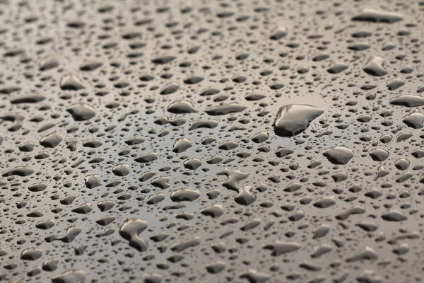 Gocce di pioggia o goccia d'acqua sul cofano dell'auto. Gocce di pioggia o — Foto Stock