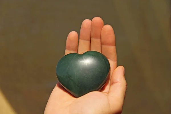 La mano tiene il cuore da pietra naturale giada verde. Cuore dentro — Foto Stock
