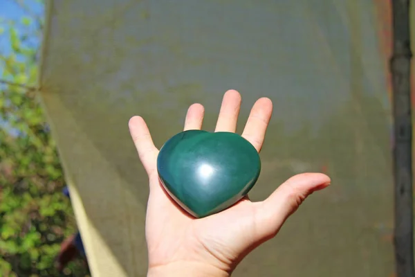 La mano tiene il cuore da pietra naturale giada verde. Cuore dentro — Foto Stock