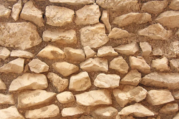 Background of brown, beige and gray stones. The old wall of ston