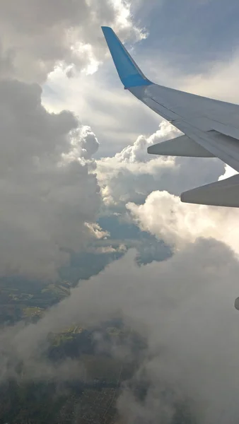 Vliegtuig vleugel uitzicht uit het raam op de bewolkte hemel backgroun — Stockfoto