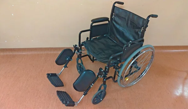 Carruagem com deficiência. Cadeira de rodas preta no hospital para o tran — Fotografia de Stock