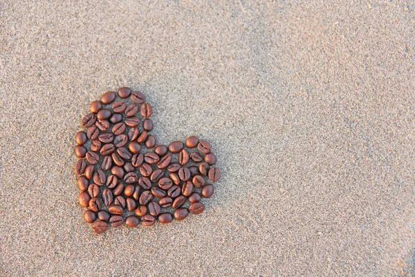 Hart van koffie. Granen van koffie zijn aangelegd op zand in de fo — Stockfoto