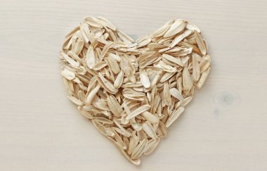 Ayçiçeği çekirdeği tarafından yapılan bir kalp. Tohumlardan atık yığını