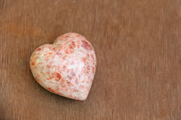 Coração rosa feito de pedra natural rhodochrosite. Um coração em forma s — Fotografia de Stock