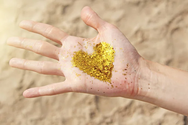 A lány kezében egy arany csillogó szív. Szív a t — Stock Fotó