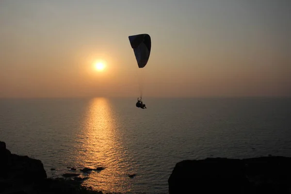 A paraglider against the background of the sea and sunset or daw