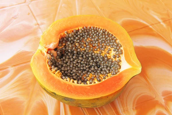 Orange open papaya with black seeds. Papaya close-up. Fruits of