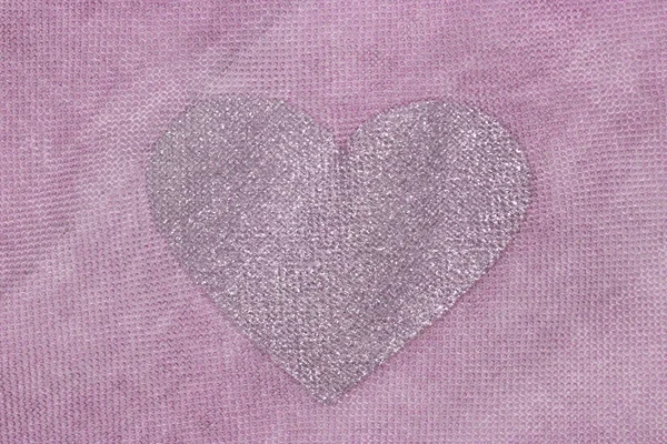 Coração de prata em um fundo rosa de tecido de algodão. Pas românticas — Fotografia de Stock