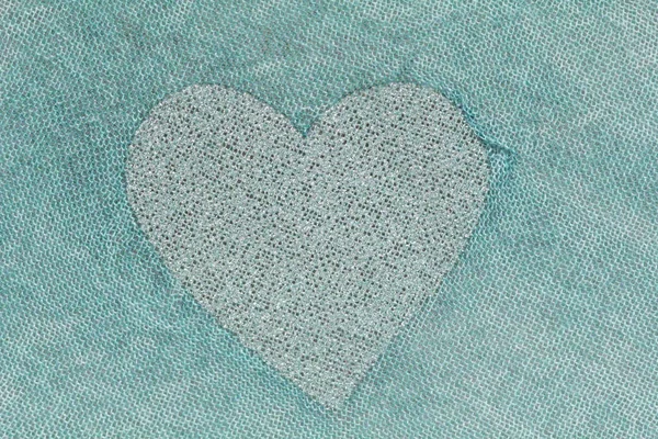 Coração de prata em um fundo verde de tecido de algodão. pa romântico — Fotografia de Stock