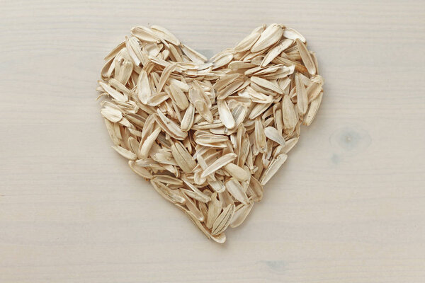 A heart made by lot of sunflower seeds. Pile of waste from seeds