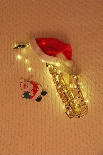 Новогодняя открытка - саксофон, гирлянда, Санта-Клаус, красная шапочка — стоковое фото