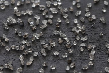 Siyah bir arka plan üzerinde dağınık elmas. Ham elmas ve minin