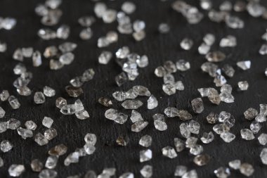 Siyah bir arka plan üzerinde dağınık elmas. Ham elmas ve minin