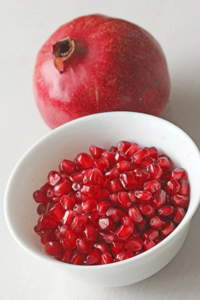 Grains of Red Ripe Pomegranate Lie in a White Bowl. Big Ripe Red