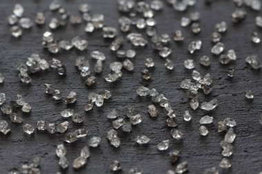 Siyah bir arka plan üzerinde dağınık elmas. Ham elmas ve minin