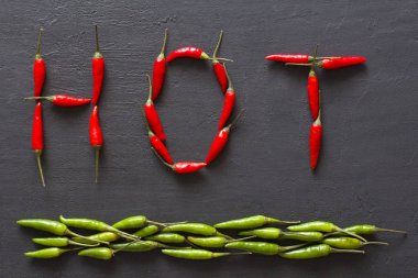 Siyah karanlık arka planda kelime sıcak kırmızı sıcak Chili Peppers