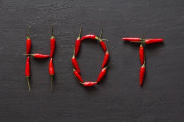 Siyah karanlık arka planda kelime sıcak kırmızı sıcak Chili Peppers