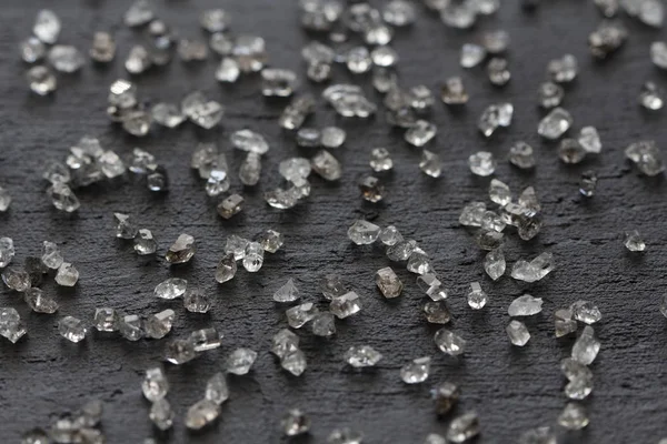 Siyah bir arka plan üzerinde dağınık elmas. Ham elmas ve minin